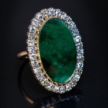 antique ring set with cabochon cut emerald surrounded by diamonds